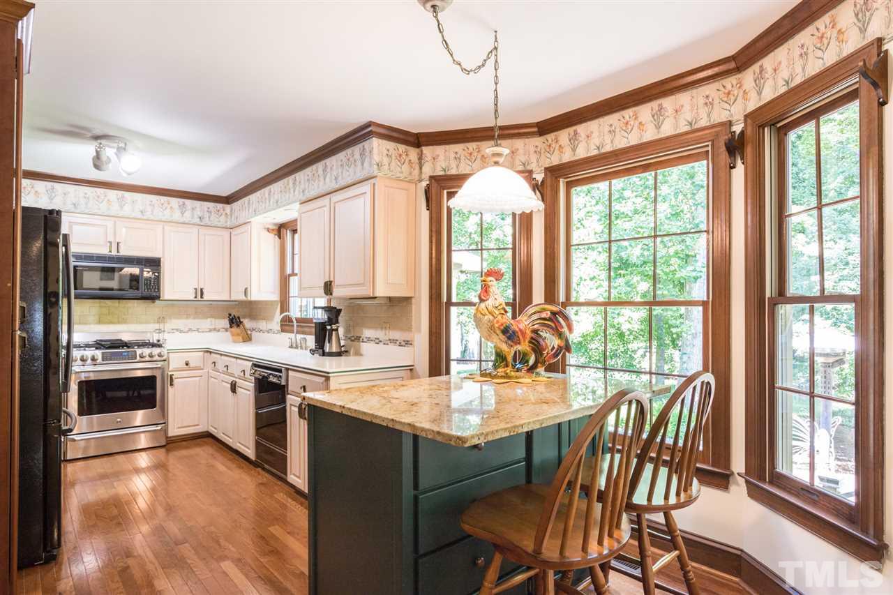 1812 Albacore Lane Raleigh, NC 27612 - Photo 8 of 30 a kitchen with a table chairs stove and cabinets