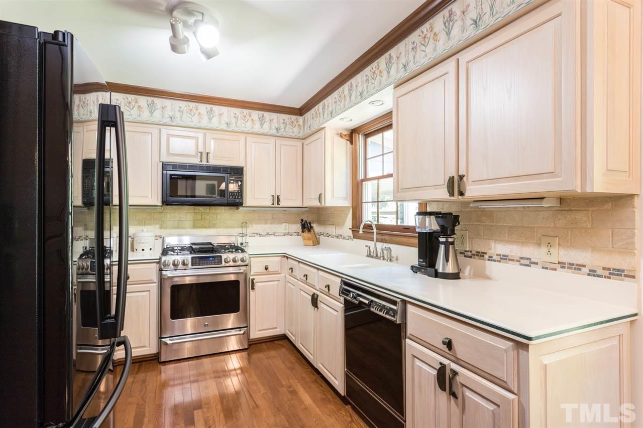 1812 Albacore Lane Raleigh, NC 27612 - Photo 9 of 30 a kitchen with stainless steel appliances granite countertop a sink a stove a refrigerator cabinets and a window