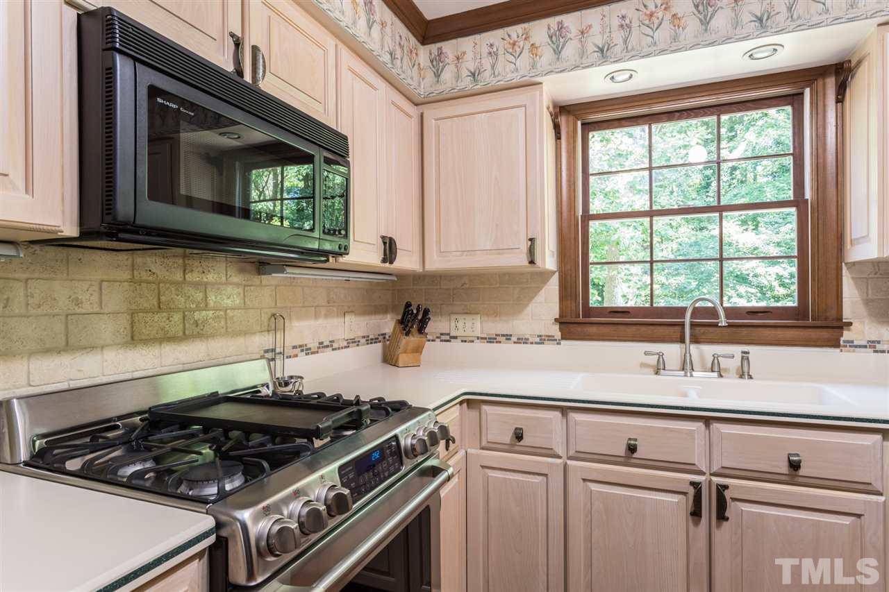 1812 Albacore Lane Raleigh, NC 27612 - Photo 10 of 30 a kitchen with a stove and a microwave