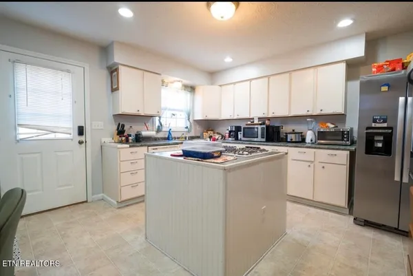 a kitchen with cabinets a sink a window and stainless steel appliances