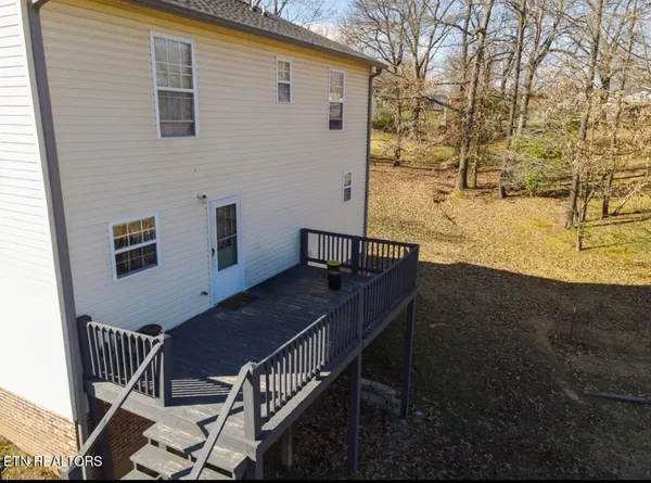 a view of a house with backyard and trees
