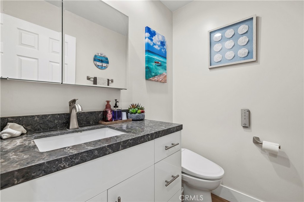 5602 Las Virgenes Road, Unit 79 Calabasas, CA 91302 - Photo 20 of 56 a bathroom with a granite countertop sink a toilet and a mirror