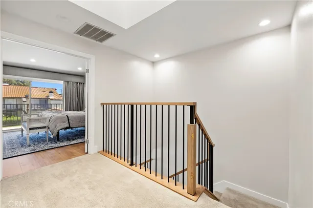 a bedroom with a bed a dresser and a large window