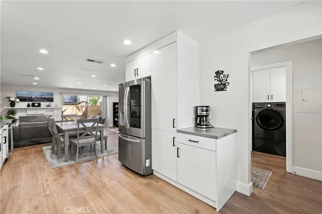 a kitchen with a table chairs refrigerator and cabinets