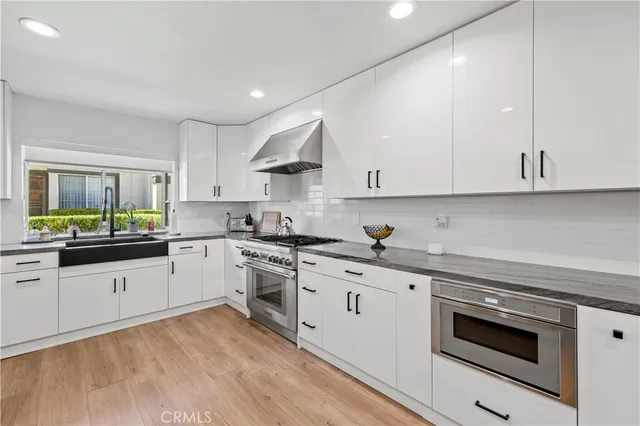 a kitchen with granite countertop white cabinets and white appliances