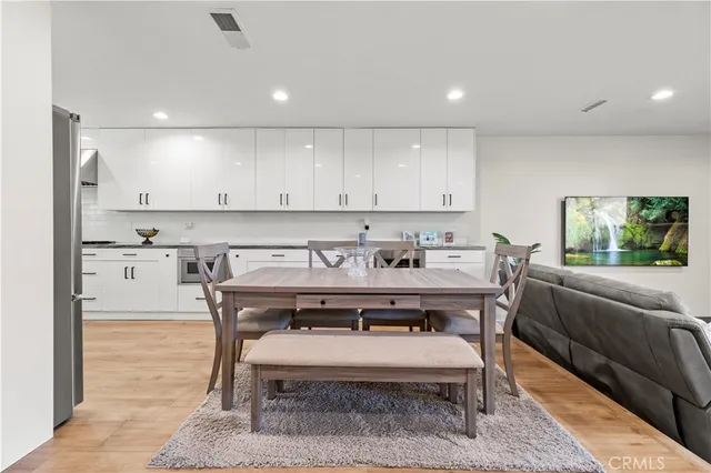 a view of a kitchen with kitchen island a dining table and chairs
