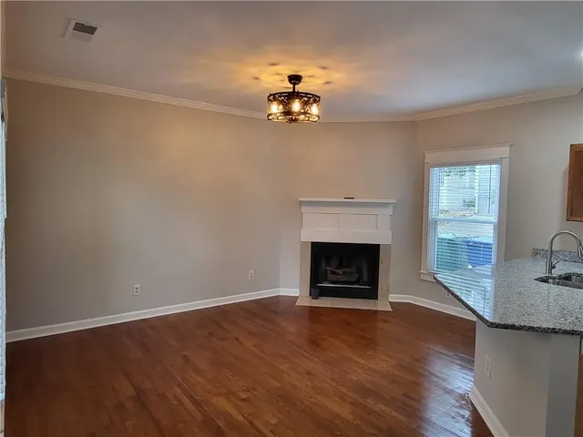 an empty room with a fireplace and wooden floor