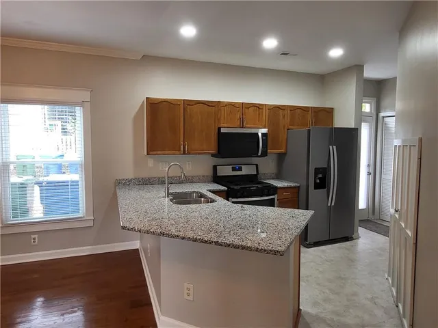 a kitchen with stainless steel appliances granite countertop a refrigerator a sink a stove a microwave and island