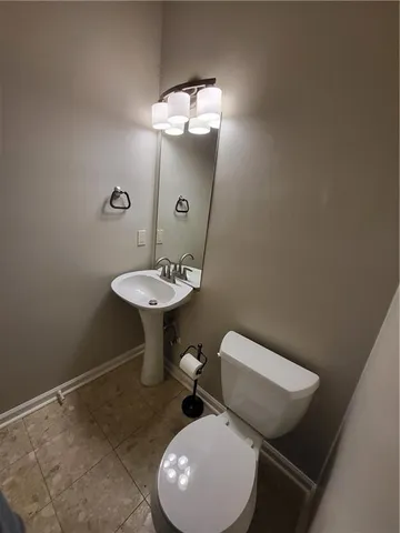 a bathroom with a toilet a sink and mirror