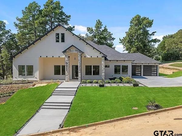 a front view of a house with a garden and yard
