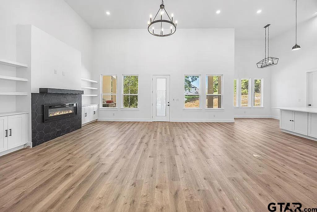 4504 Triggs Trace Tyler, TX 75709 - Photo 14 of 46 an empty room with wooden floor fireplace and windows