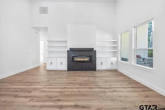 a view of an empty room with a fireplace and a window