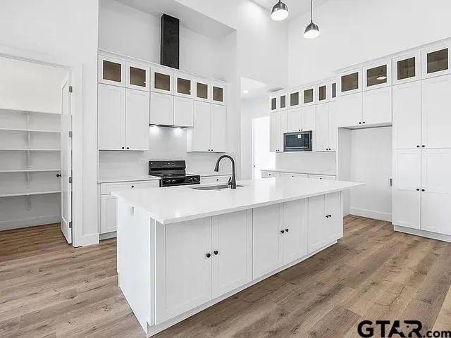 a kitchen with stainless steel appliances a sink stove and cabinets