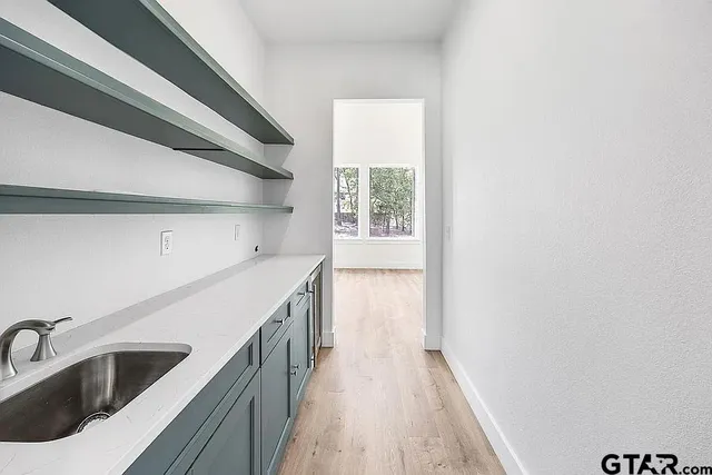 a view of a kitchen with a sink and dishwasher with wooden floor
