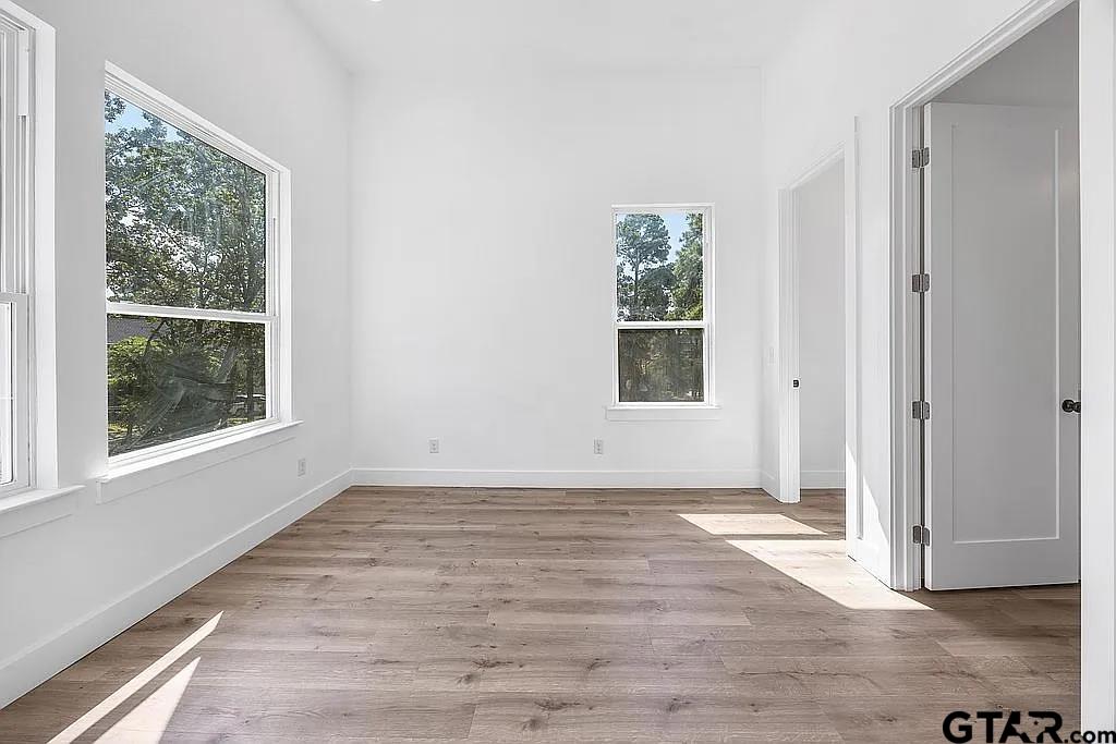 4504 Triggs Trace Tyler, TX 75709 - Photo 29 of 46 an empty room with wooden floor and windows