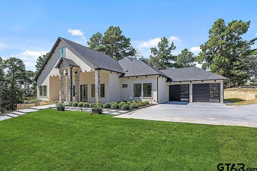 4504 Triggs Trace Tyler, TX 75709 - Photo 3 of 46 a front view of a house with a garden and trees