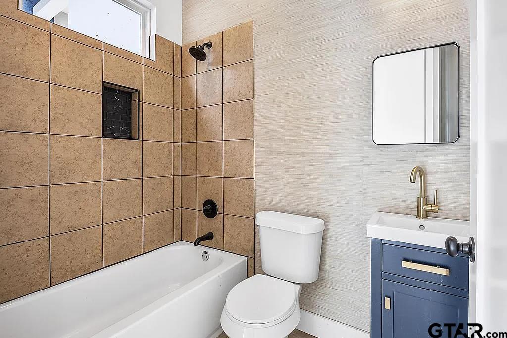 4504 Triggs Trace Tyler, TX 75709 - Photo 34 of 46 a bathroom with a toilet a sink a mirror and vanity