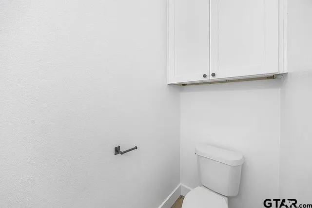a white toilet sitting next to a shower