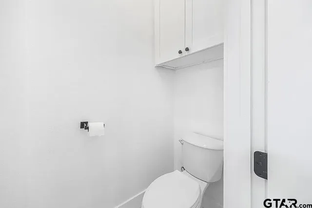 a white toilet sitting next to a shower