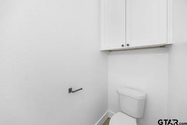 a white toilet sitting next to a shower