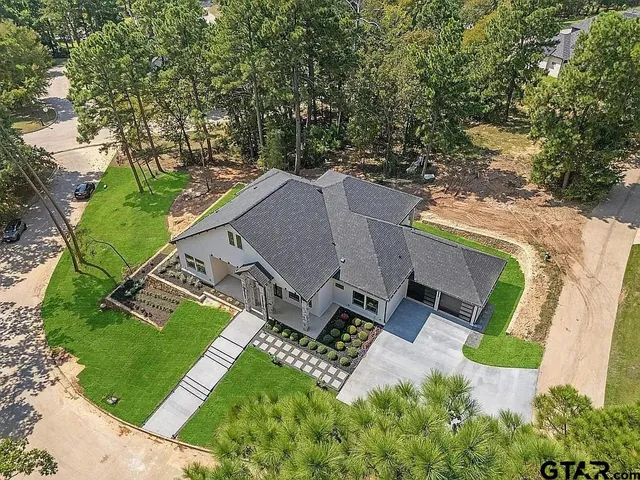 an aerial view of a house with a garden and trees