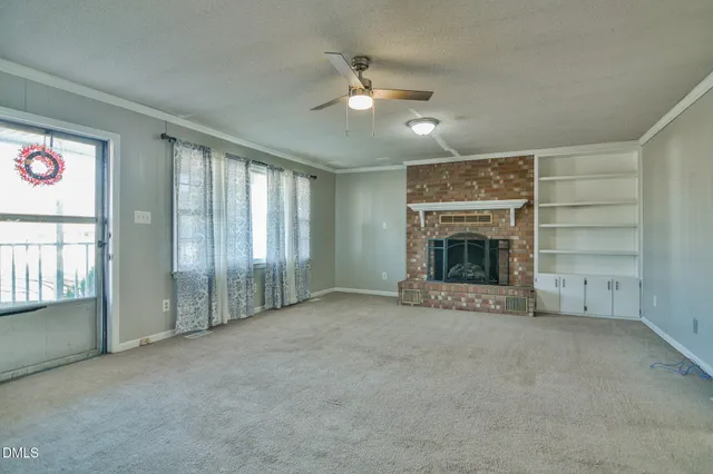 an empty room with fireplace and fan