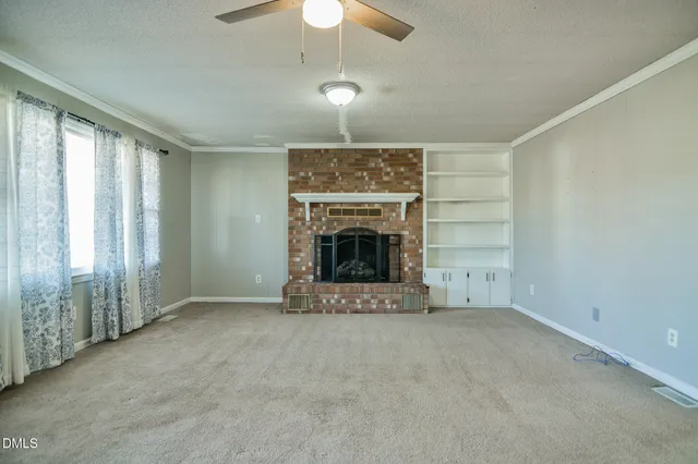 an empty room with windows and a kitchen