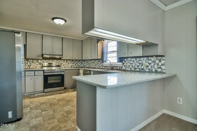 a kitchen with white cabinets and refrigerator