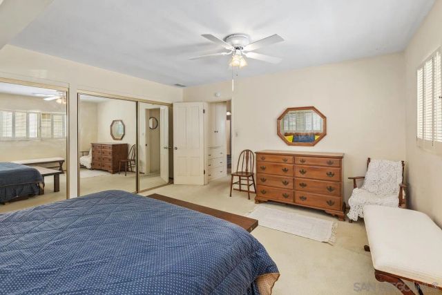 a bedroom with a bed a chandelier and a dresser
