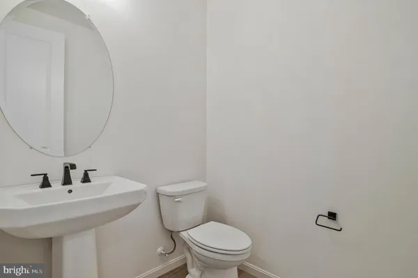 a view of a utility room with closet empty shelves and wooden floor