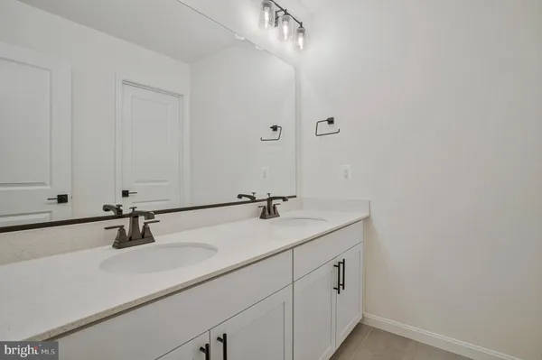 a bathroom with double sink and a mirror