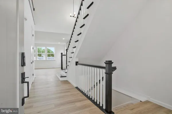 a view of staircase with lots of frames on wall and wooden floor