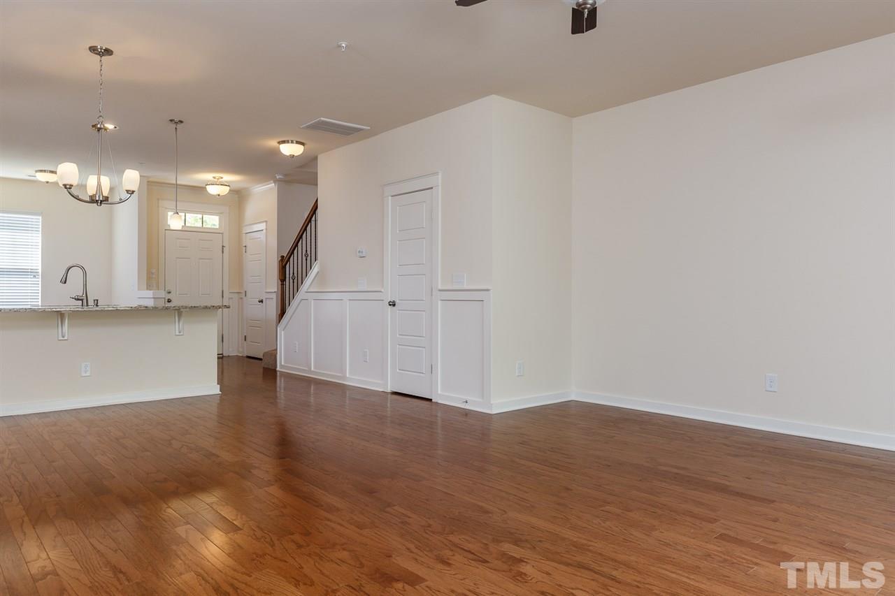 7841 Allscott Way Raleigh, NC 27612 - Photo 4 of 20 a view of a room with wooden floor and a ceiling fan