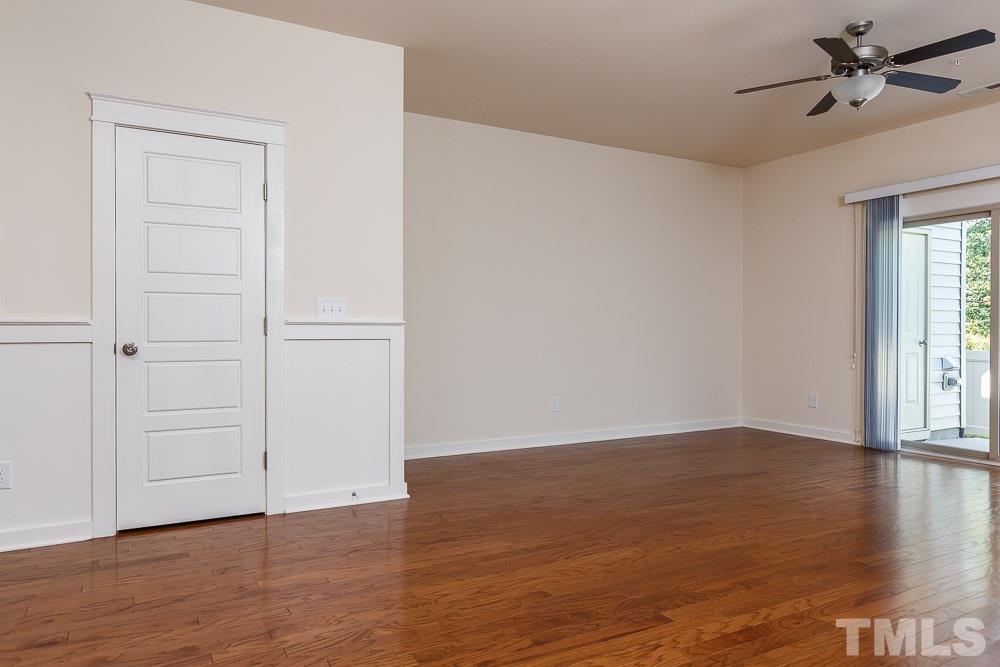 7841 Allscott Way Raleigh, NC 27612 - Photo 5 of 20 a view of an empty room with wooden floor and a window