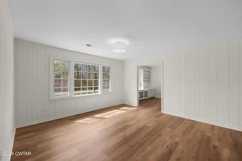 a view of empty room with wooden floor