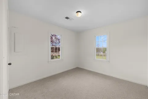 a view of front door with hallway and wooden floor