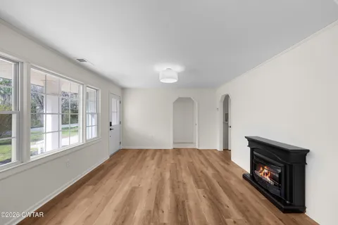 a view of empty room with wooden floor and fireplace