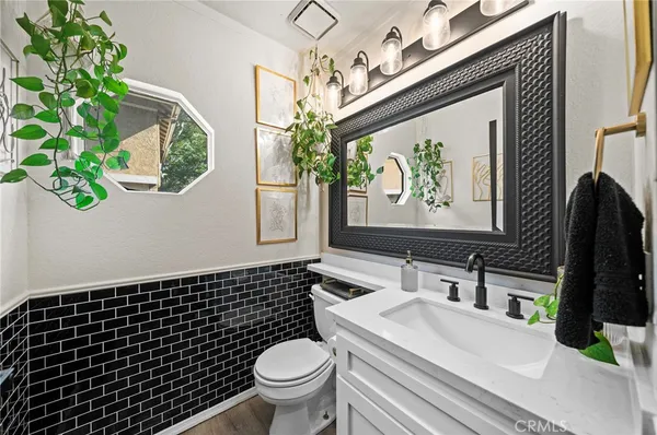 a bathroom with a sink a toilet a mirror and shower