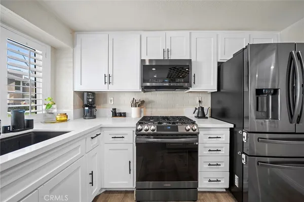 a kitchen with a refrigerator stove and white cabinets