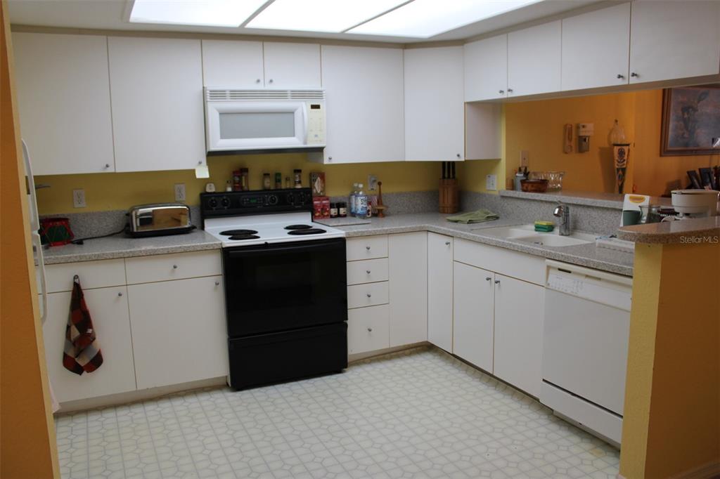 9722 Indian Key Trail, Unit 116 Seminole, FL 33776 - Photo 11 of 65 a kitchen with stainless steel appliances granite countertop a sink stove and cabinets