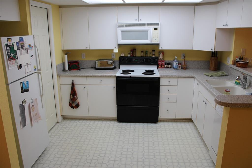 9722 Indian Key Trail, Unit 116 Seminole, FL 33776 - Photo 12 of 65 a kitchen with stainless steel appliances a stove refrigerator a sink a stove and cabinets