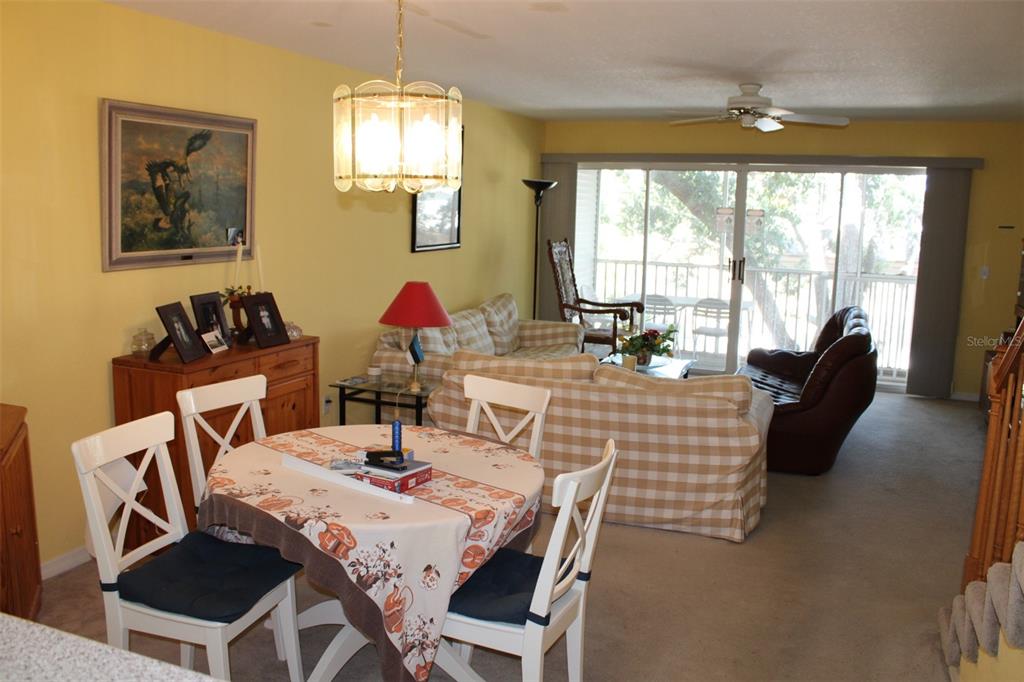 9722 Indian Key Trail, Unit 116 Seminole, FL 33776 - Photo 15 of 65 a view of a dining room with furniture a chandelier and wooden floor