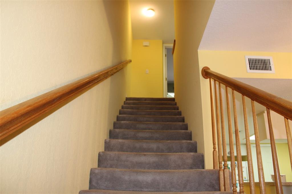 9722 Indian Key Trail, Unit 116 Seminole, FL 33776 - Photo 19 of 65 a view of staircase with lots of frames on wall