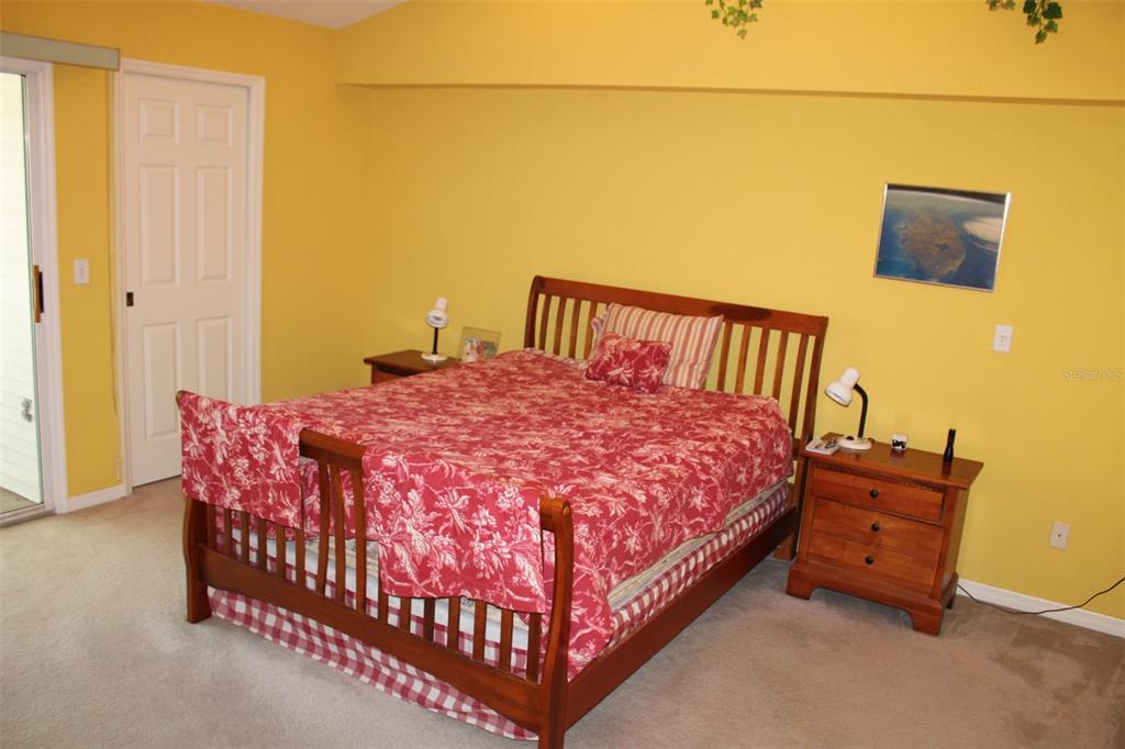 9722 Indian Key Trail, Unit 116 Seminole, FL 33776 - Photo 35 of 65 a large bed sitting in a bedroom next to a bathroom