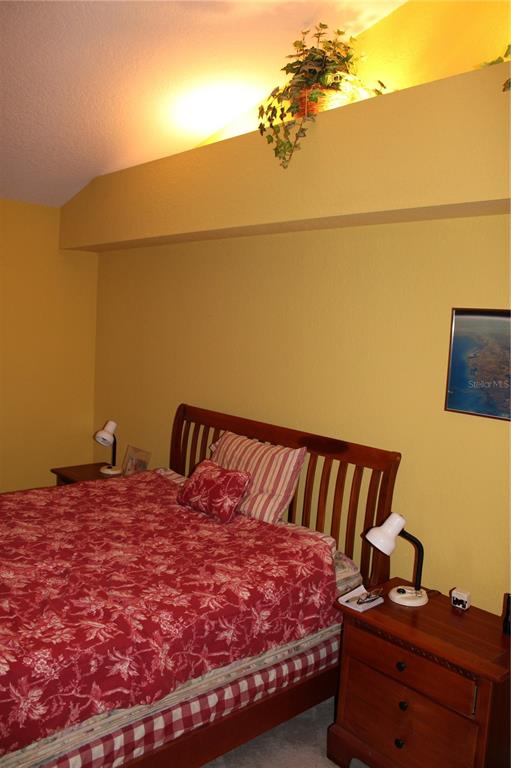 9722 Indian Key Trail, Unit 116 Seminole, FL 33776 - Photo 37 of 65 a bed sitting in a bedroom next to a bathroom