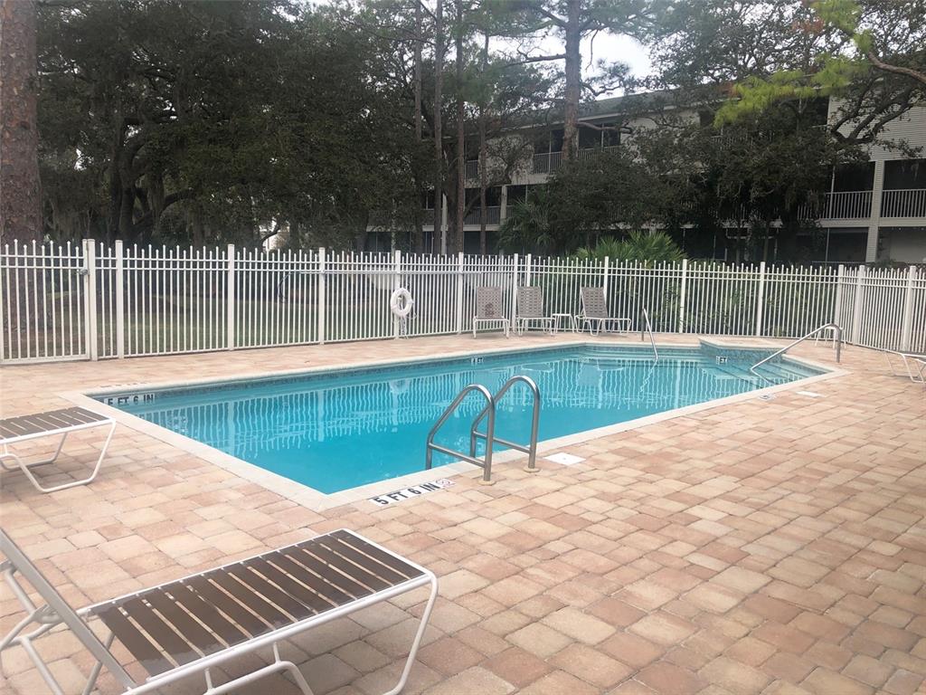 9722 Indian Key Trail, Unit 116 Seminole, FL 33776 - Photo 63 of 65 a view of a swimming pool with a yard and plants
