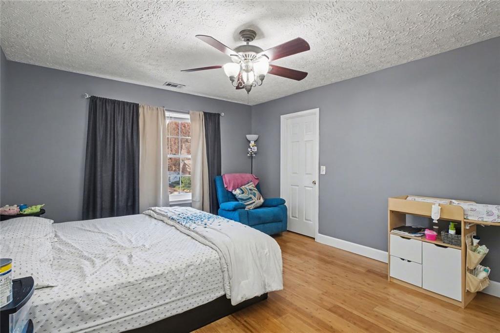 151 Ilex Drive Canton, GA 30114 - Photo 33 of 43 a bed room with a bed and a chandelier