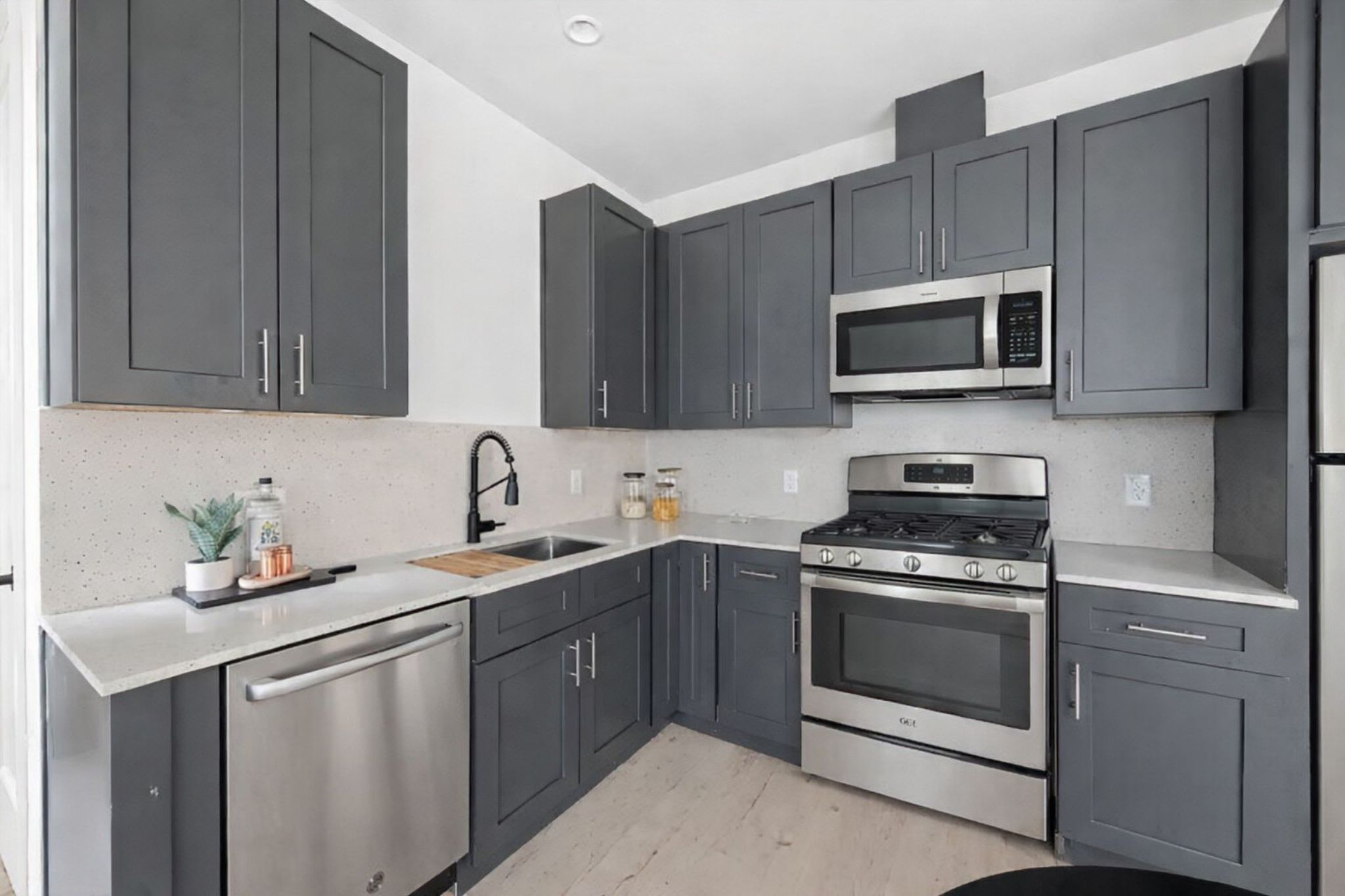1709 Maple Avenue, Unit 2B Austin, TX 78702 - Photo 26 of 28 a kitchen with stainless steel appliances granite countertop a sink stove and microwave