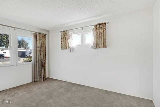 an empty room with closet and windows