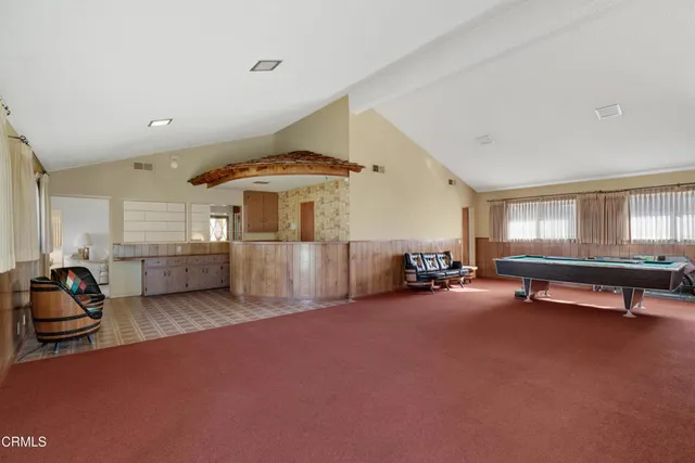 a room with pool table and windows